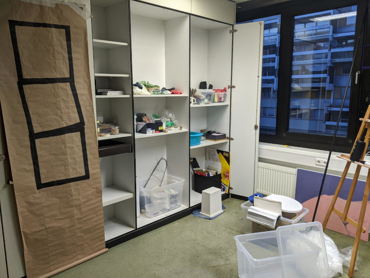 photo of a corner of the studio, shelves of supplies and boxes